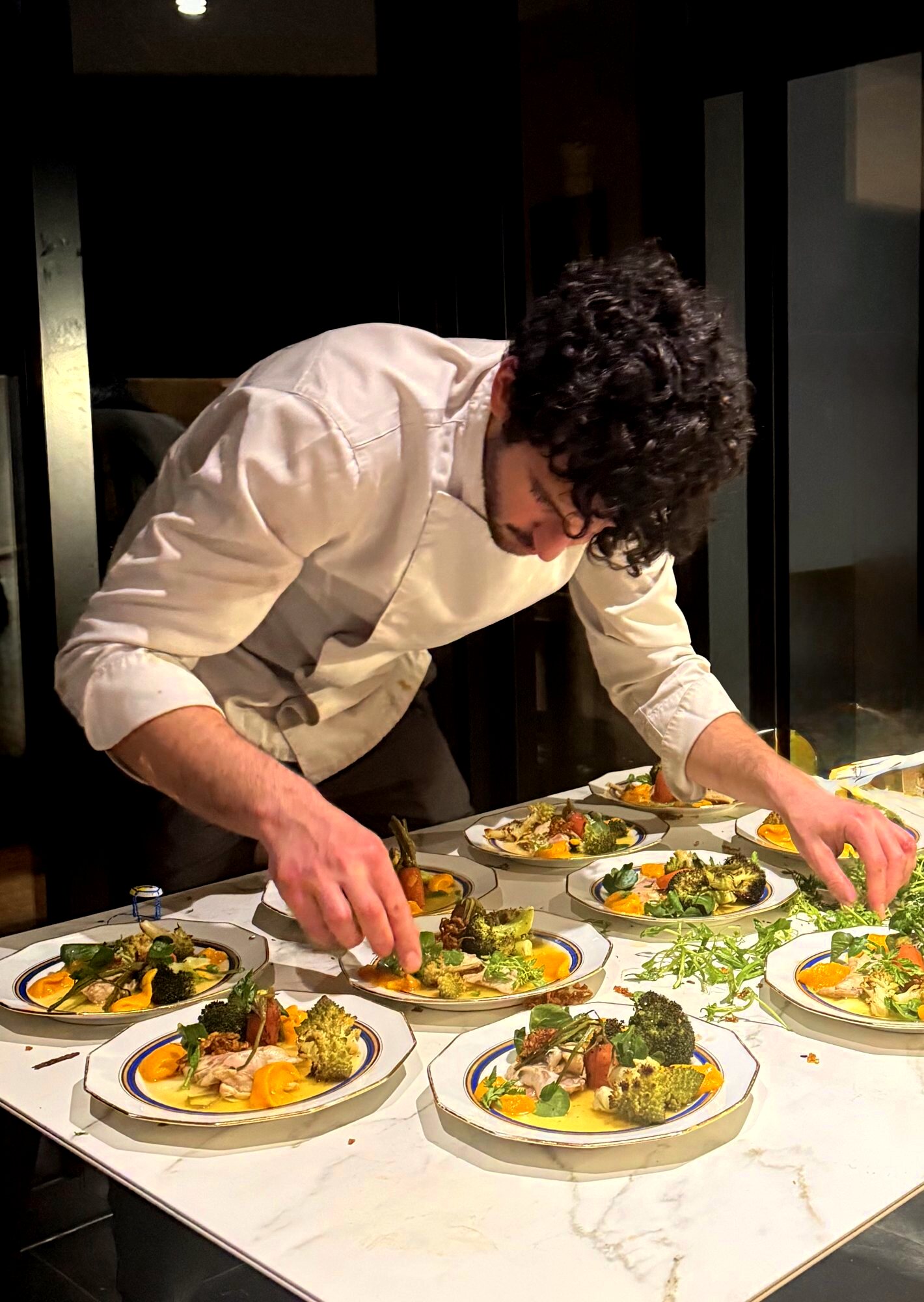 Léo dresse une série d’assiettes lors d’un dîner privé